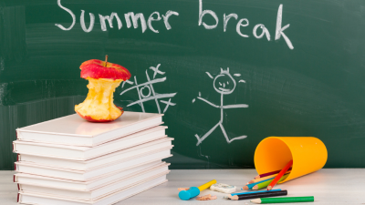 Chalkboard with “Summer break,” stack of books, apple, stick figure doodles, and scattered pencils