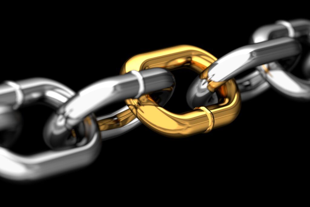 Silver chain with a gold link highlighted on a black background