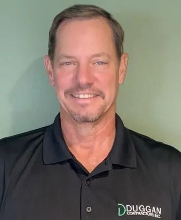 A smiling person wearing a black polo shirt with