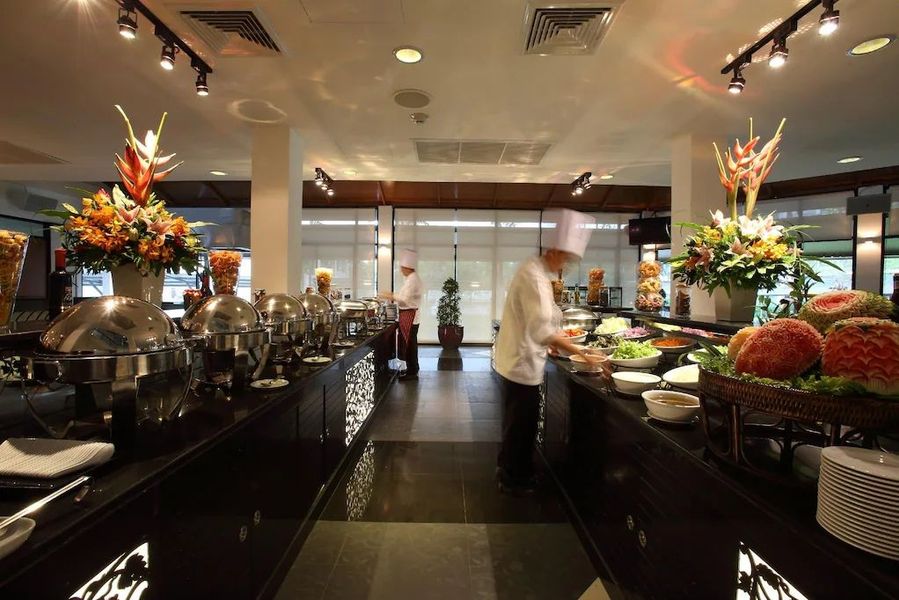 Buffet food area with chefs preparing dishes, floral arrangements, and serving stations.
