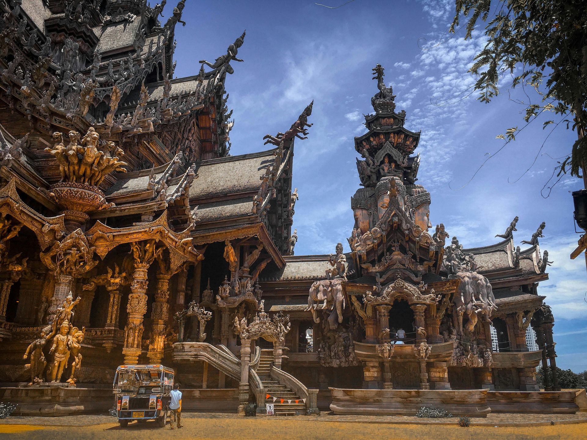 ปราสาทสัจธรรมที่ทำจากไม้แกะสลักอย่างวิจิตรงดงามในประเทศไทย ภายใต้ท้องฟ้าสีคราม