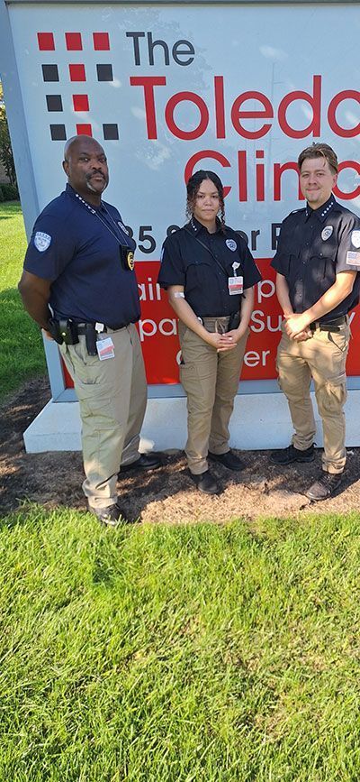 Three people in uniform stand in front of 