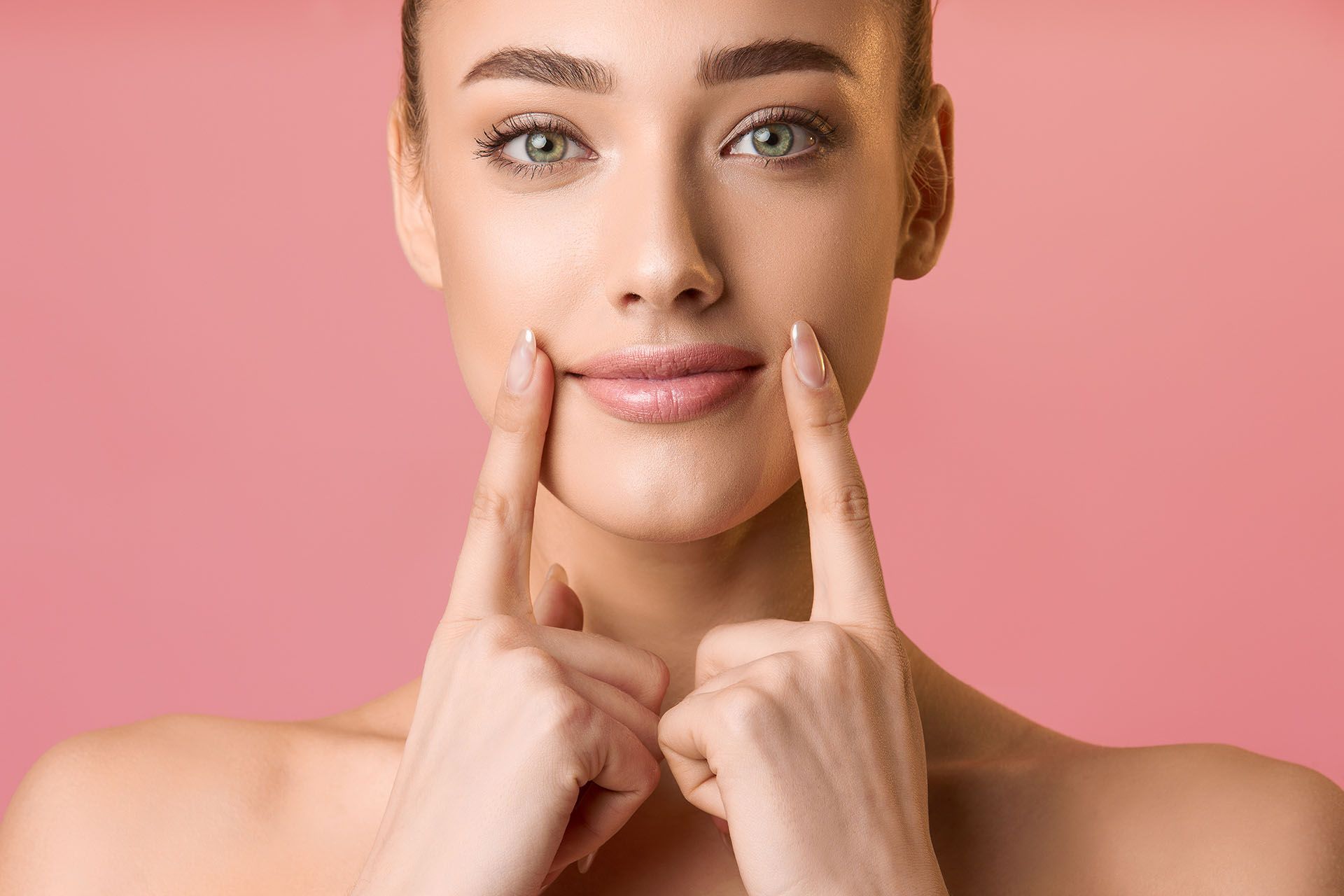 woman is touching her face and smiling