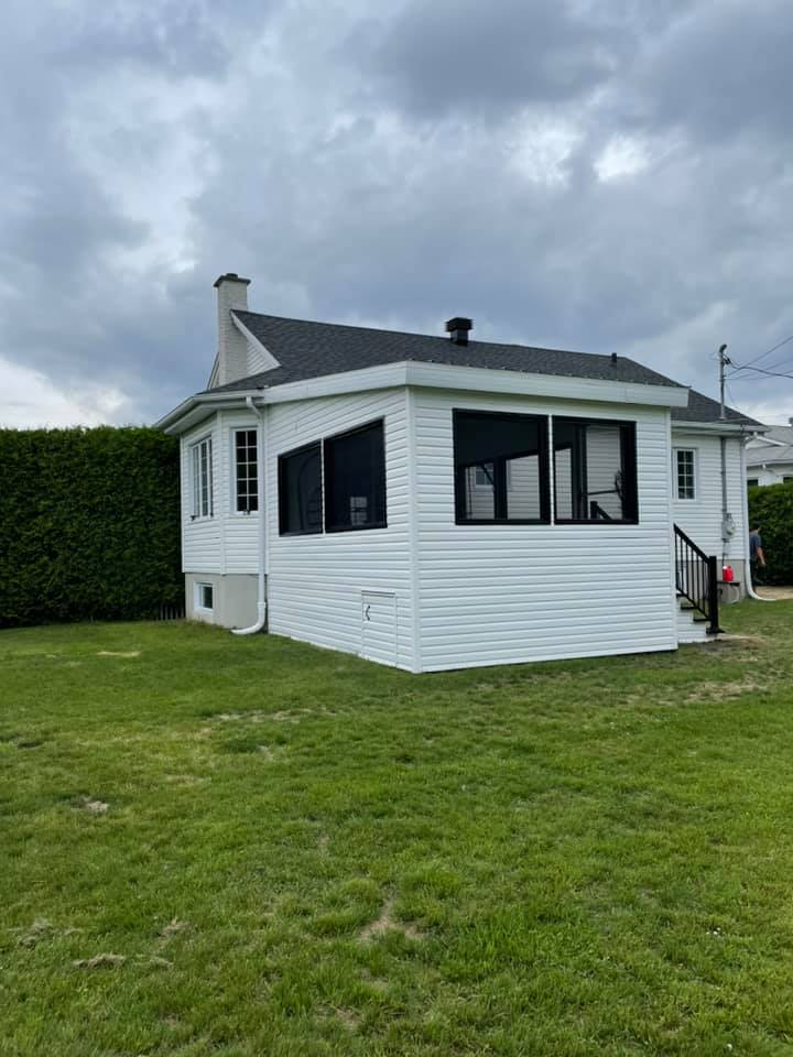 une petite maison blanche se trouve au milieu d un champ verdoyant.