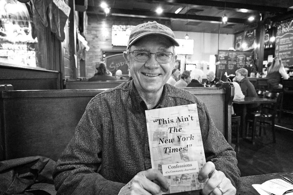 Author Tim Farmer holding his book,