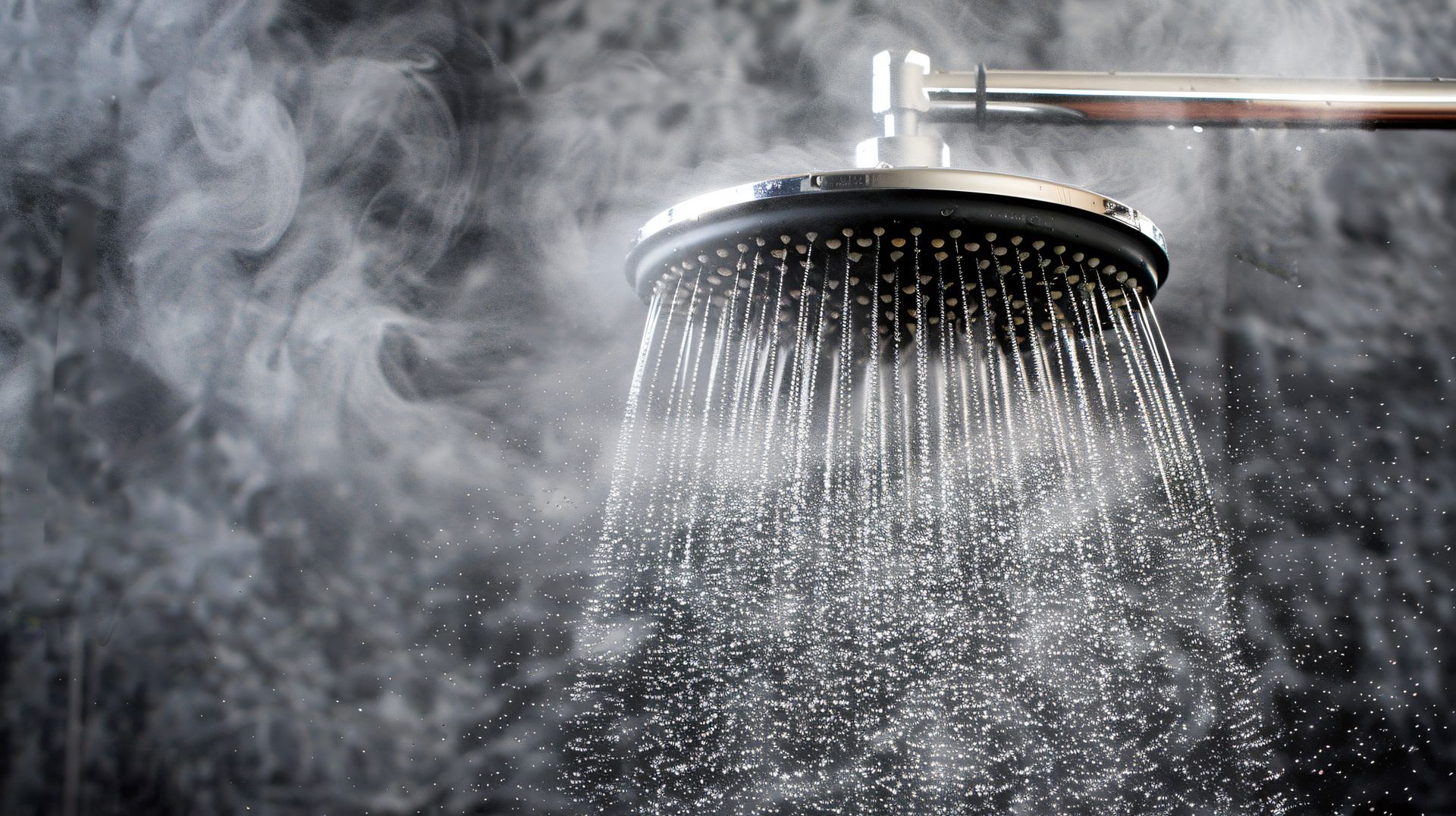 A close up of a shower head with steam coming out of it