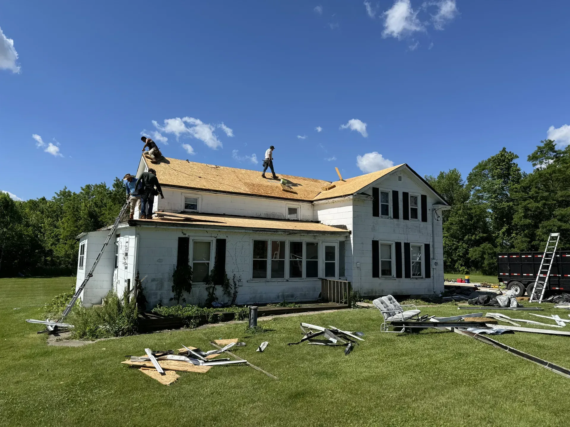 AR Exteriors crew tearing off the old roof and installing new decking on a historic farmhouse in Janesville, WI