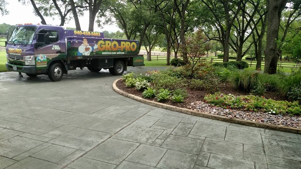 Truck with colorful “GRO-PRO” branding parked beside a landscaped park walkway.