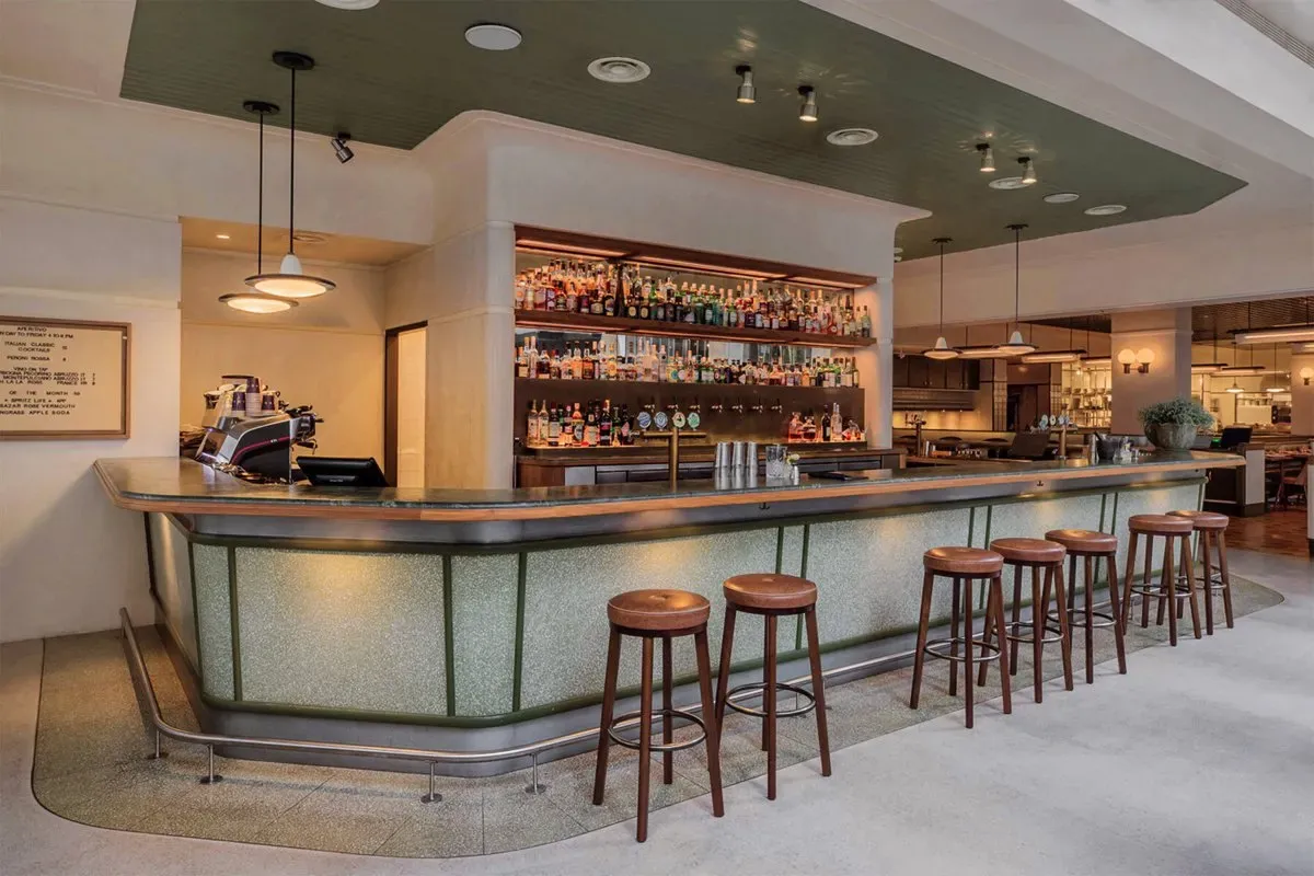 A restaurant with a long bar and stools.