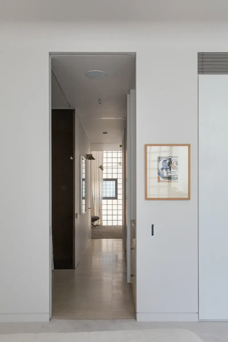 A hallway in a house with a picture on the wall.