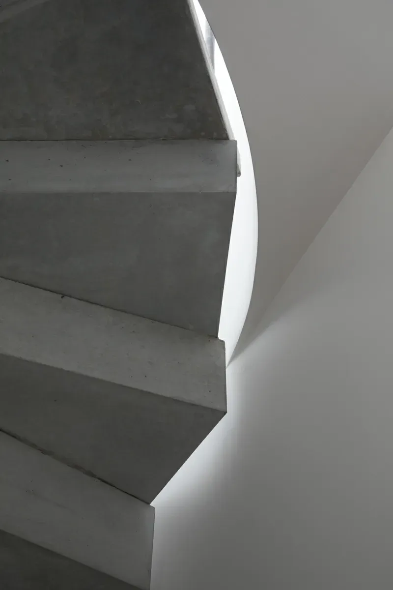 A black and white photo of a spiral staircase.