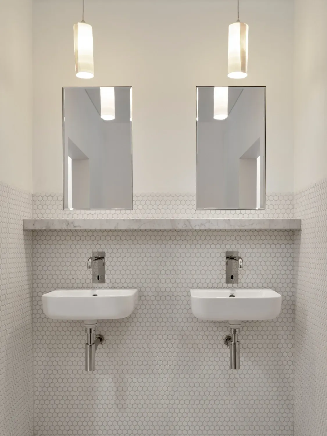 A bathroom with two sinks and two mirrors.
