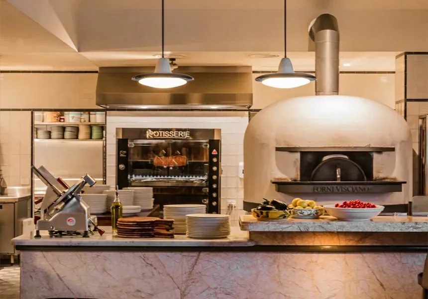 A kitchen with a pizza oven and a meat slicer