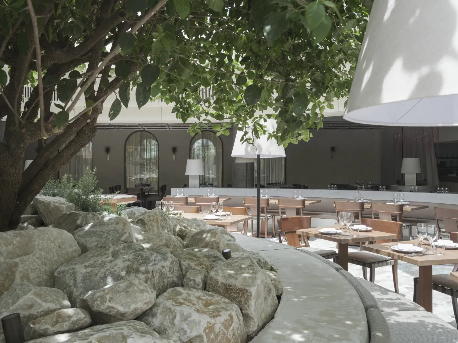 A restaurant with tables and chairs under an umbrella