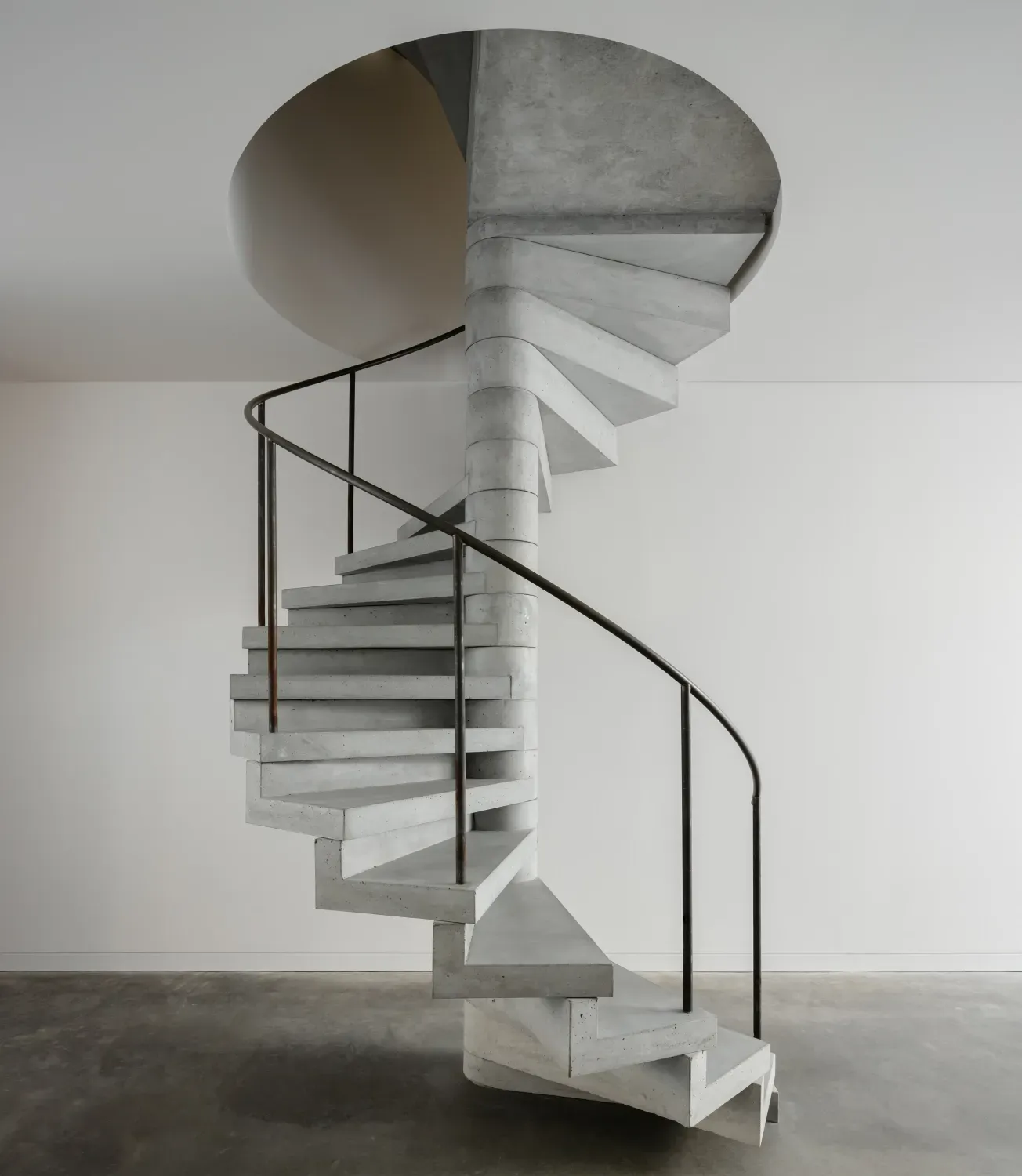 A spiral staircase with a black railing in a room