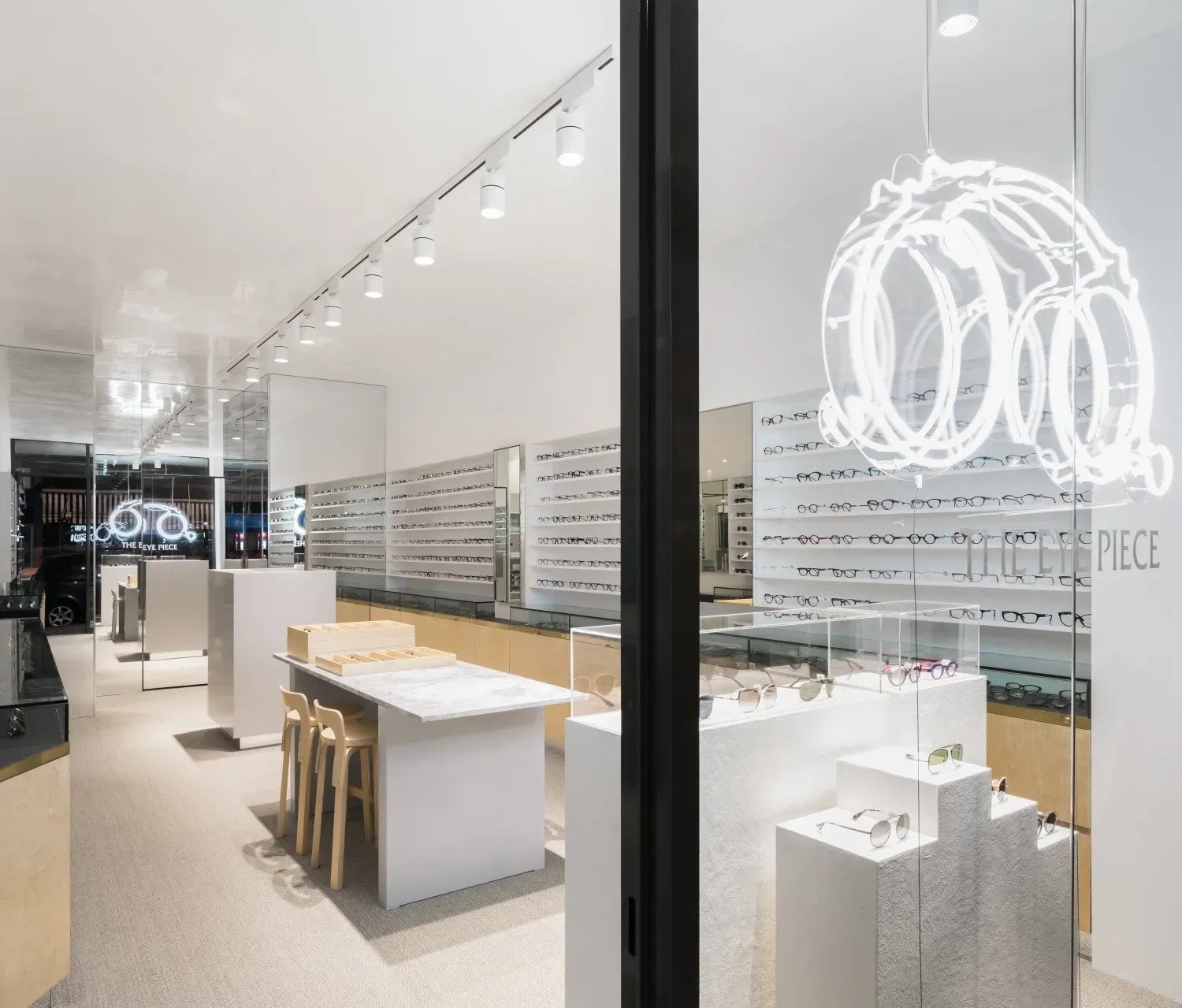 The inside of an optical shop with a table and chairs.