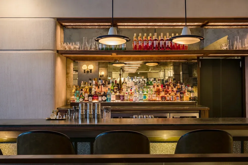 A bar with a lot of bottles of alcohol on it.
