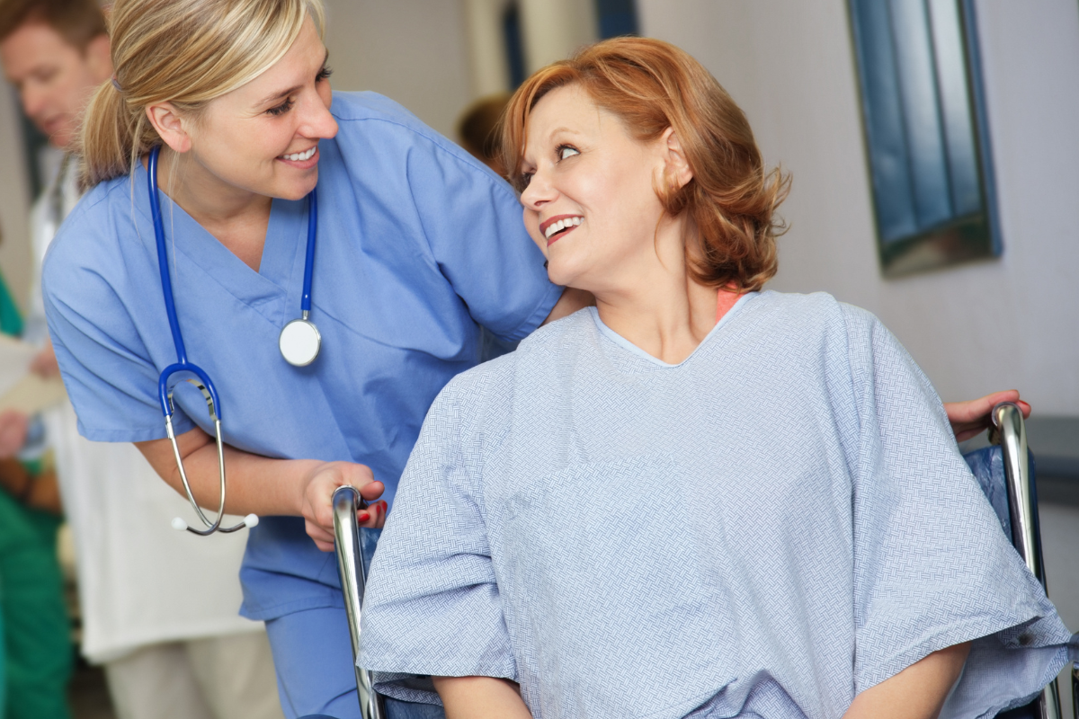 A nurse is pushing a patient in a wheelchair.