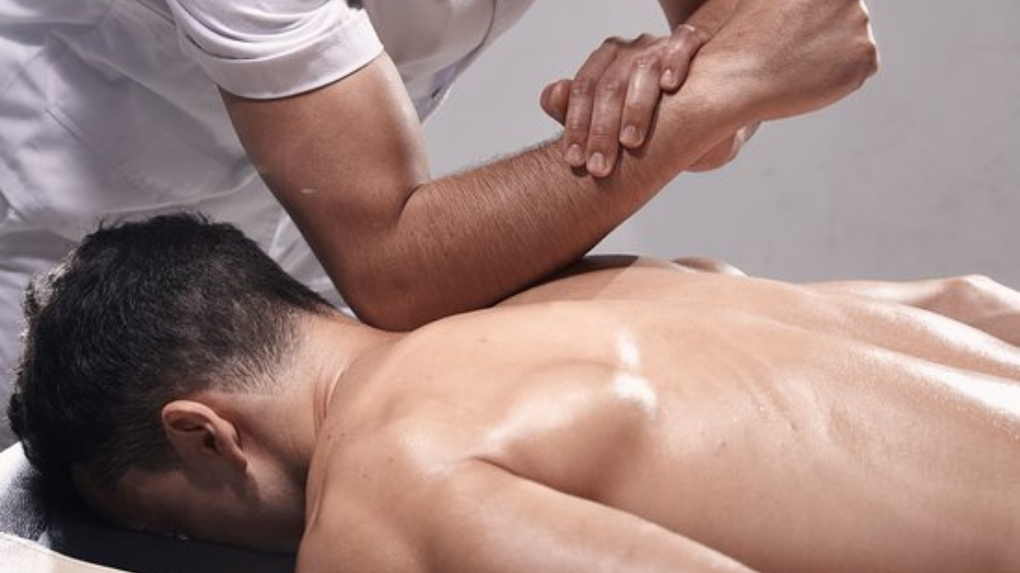 Person receiving a shoulder massage on a treatment table