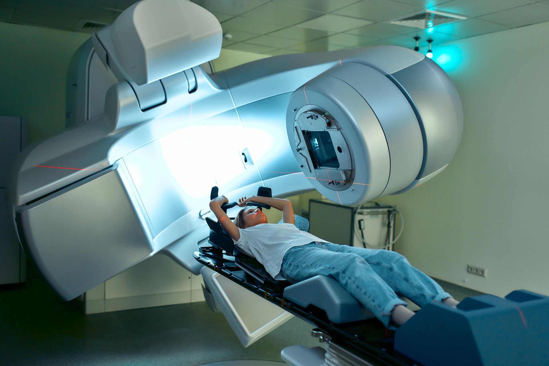 Uma pessoa está deitada em uma cama de hospital com uma máquina na cabeça.