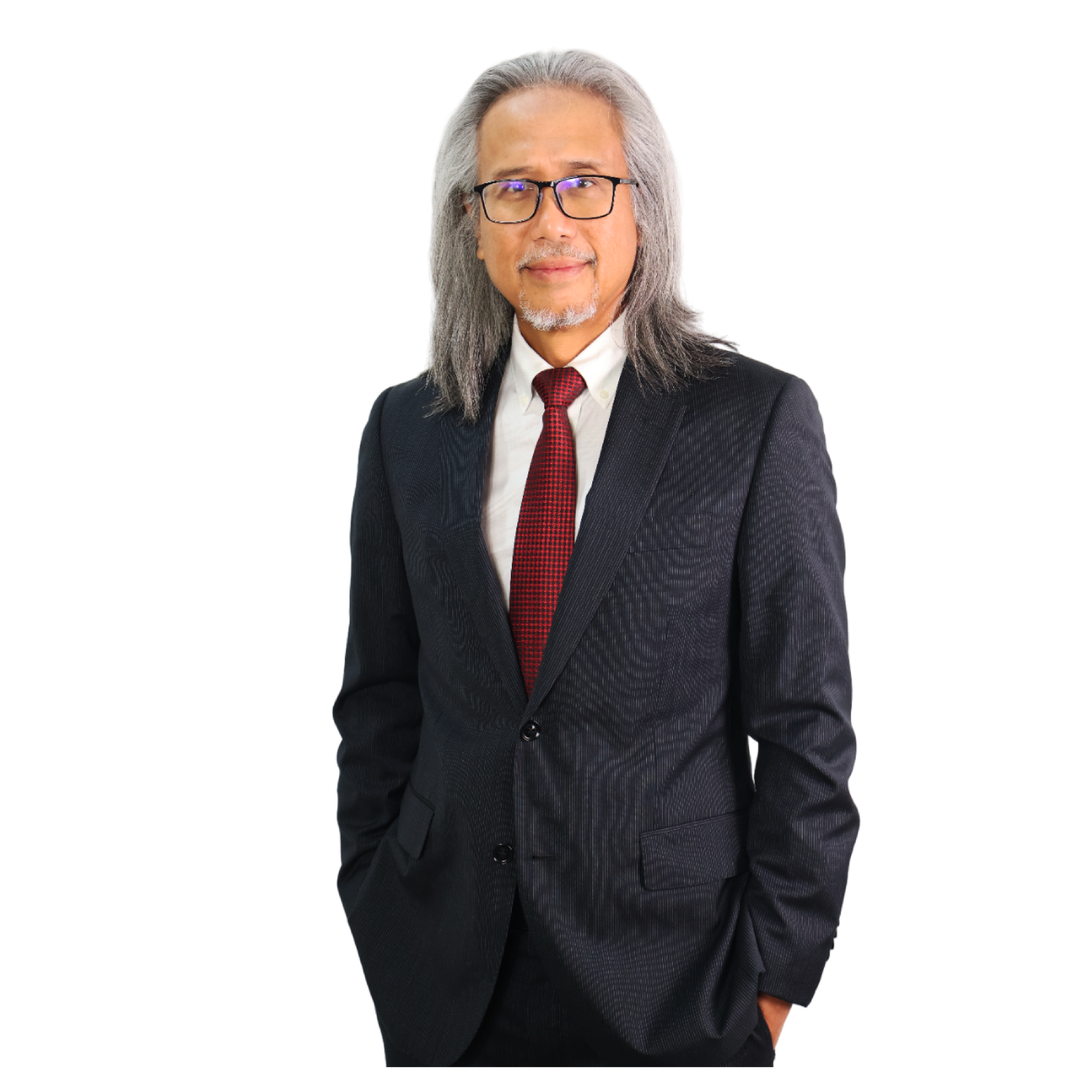 A man in a suit and tie is standing with his hands in his pockets.