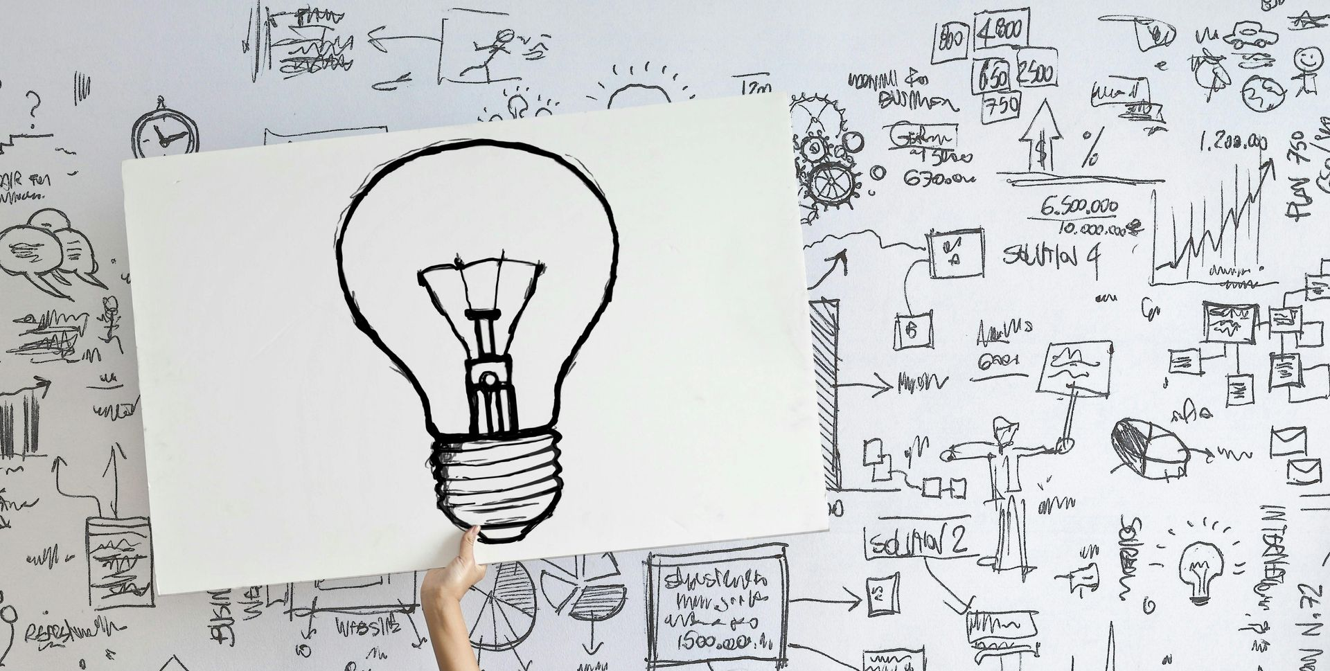 A lightbulb with strategy notes on the board. Our team uses a variety of methods to help teams to document their strategies.