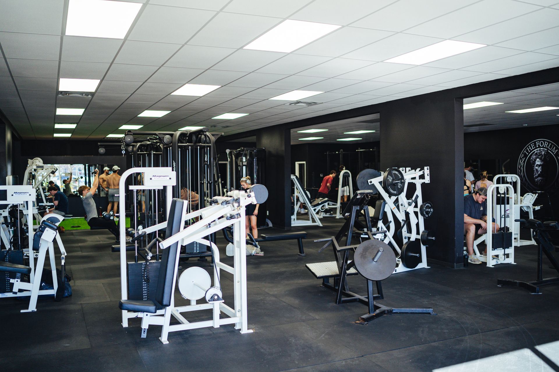 A gym filled with lots of exercise equipment and people.