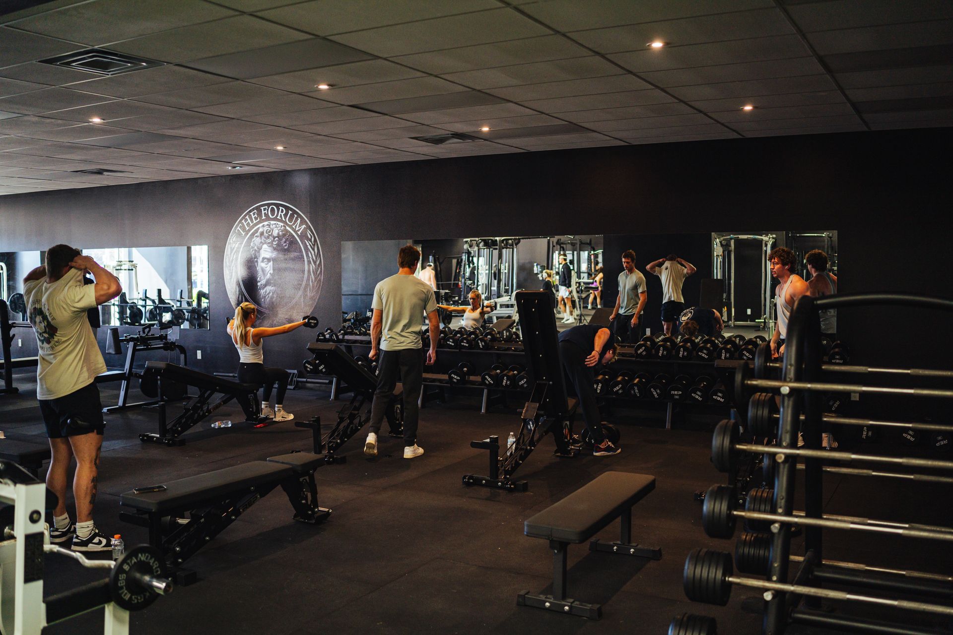 A group of people are standing in a gym.