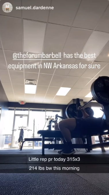 A man is lifting a barbell in a gym.