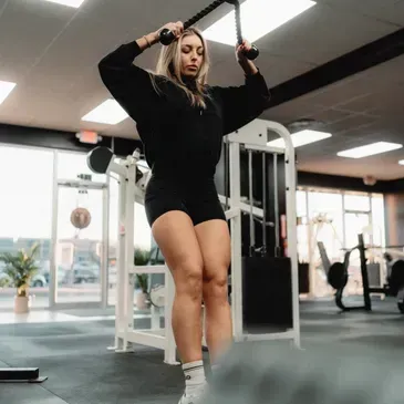 A woman is doing exercises on a machine in a gym.