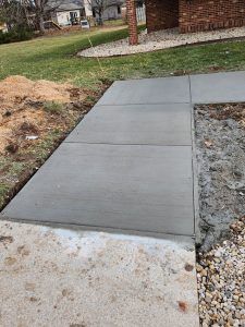 A concrete walkway is being built in front of a house.