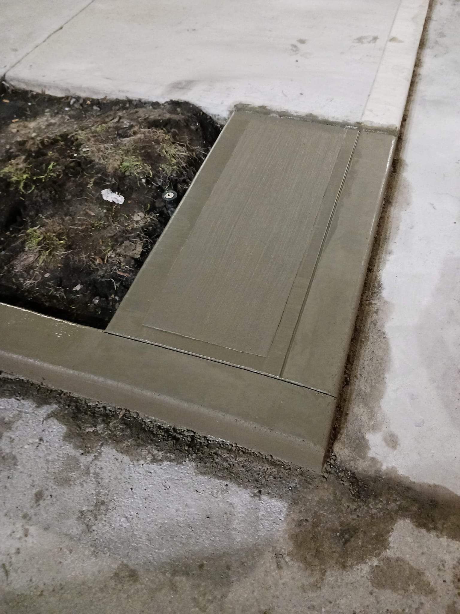 A concrete ramp is being built on the side of a road.