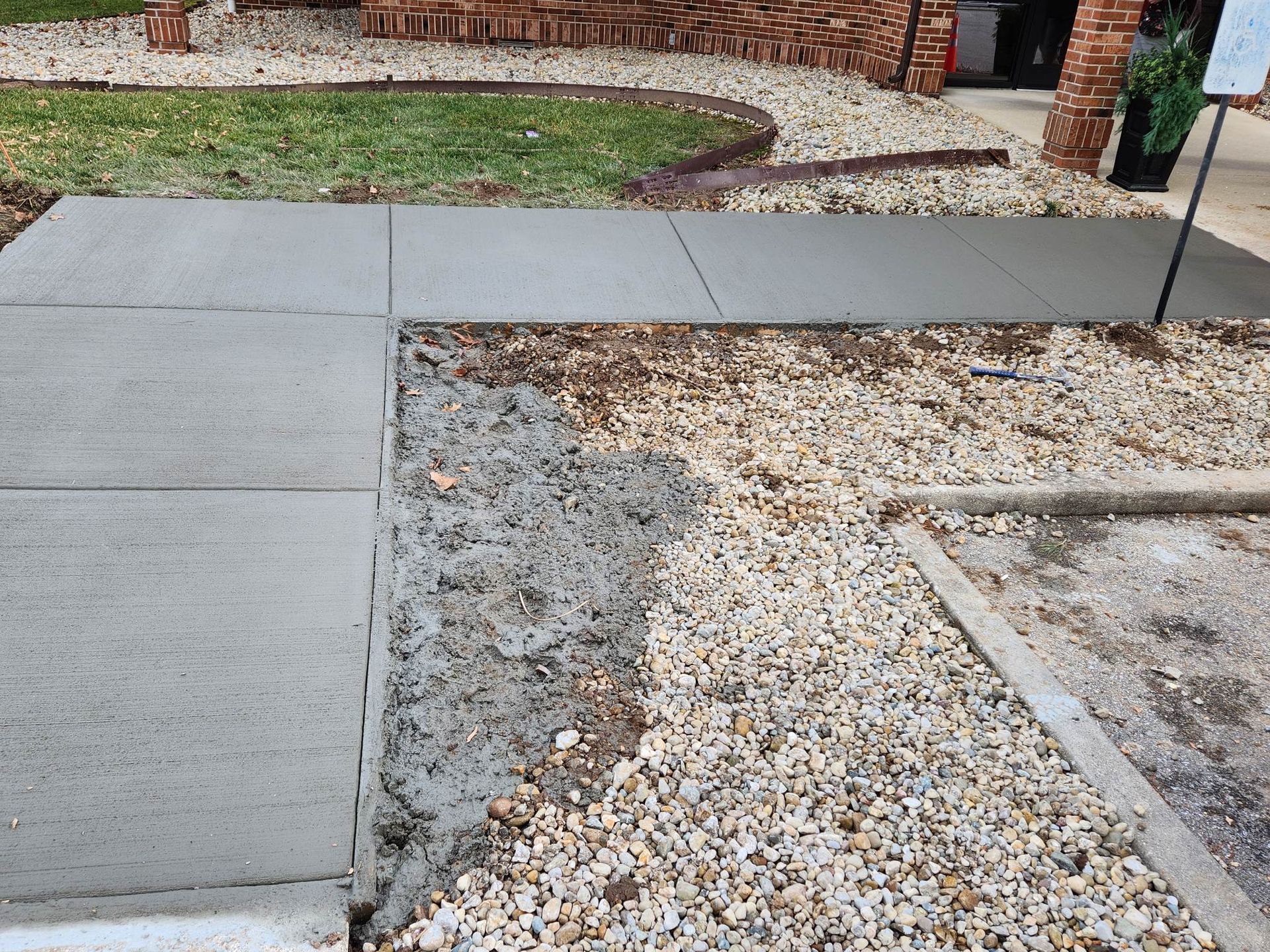 A concrete sidewalk is being built in front of a house.