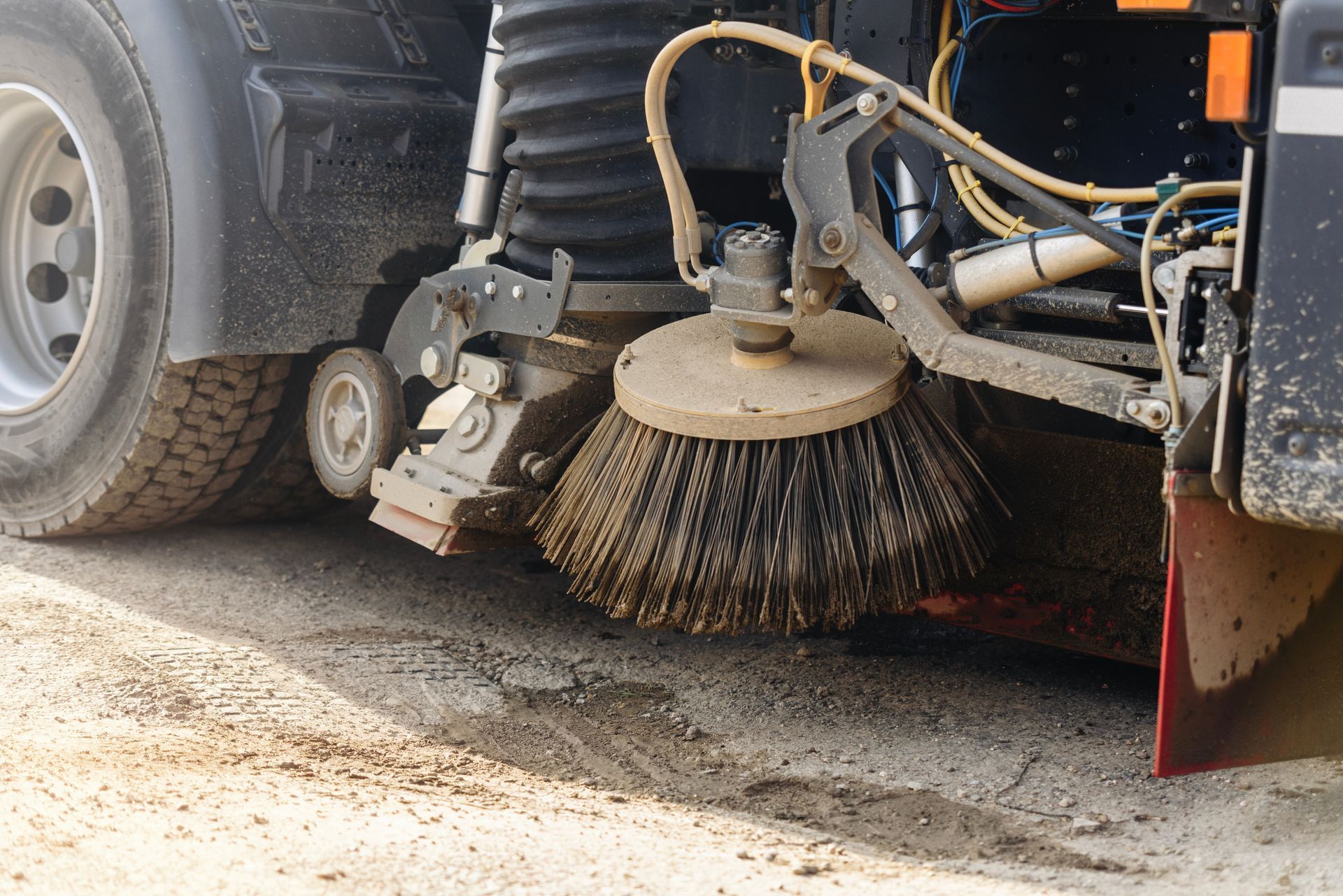 Parking lot sweeping service machine using a rotary brush to remove dirt and debris from pavement.
