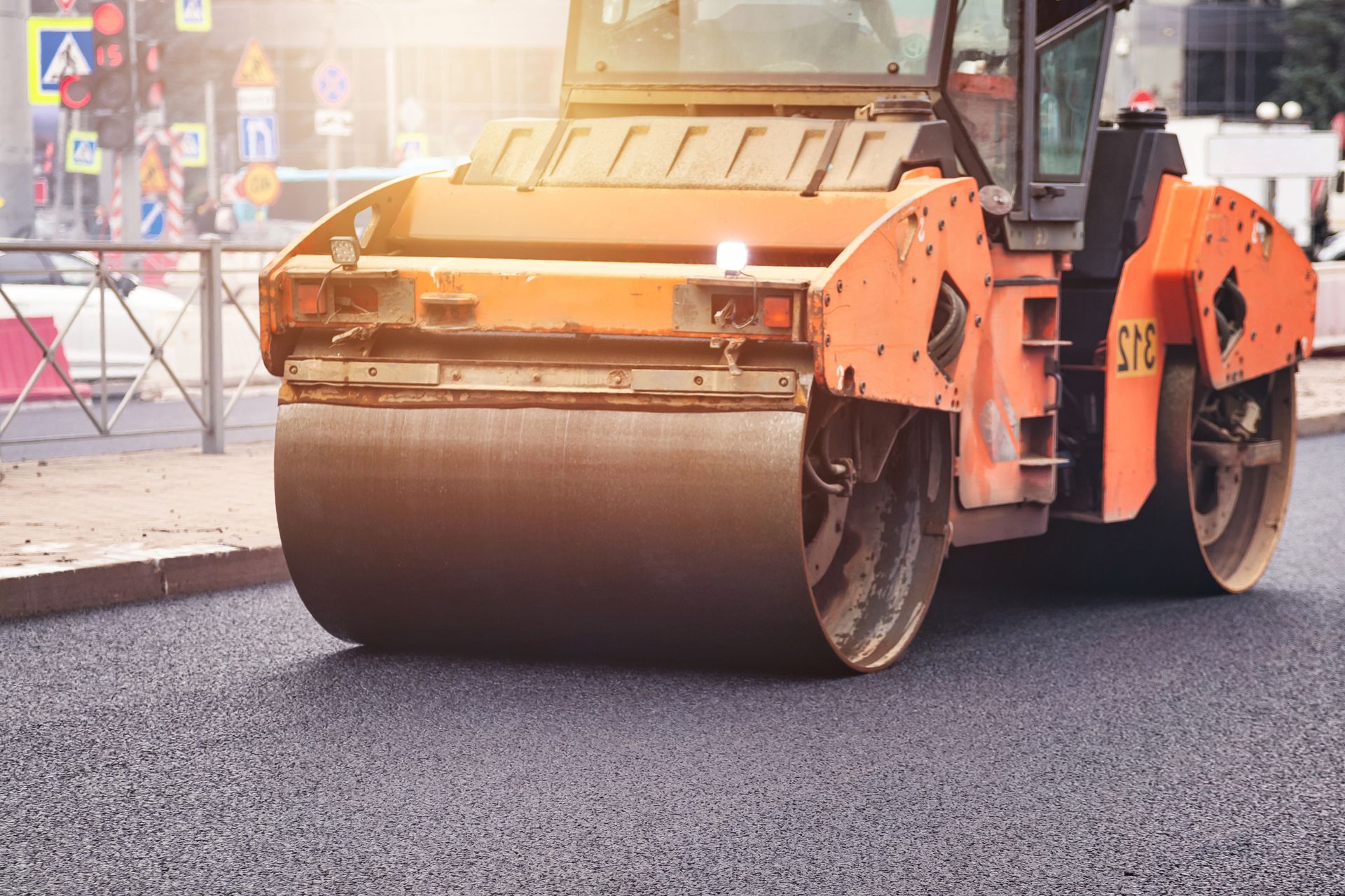 Urban street paving with heavy machinery during road construction on a busy city street.