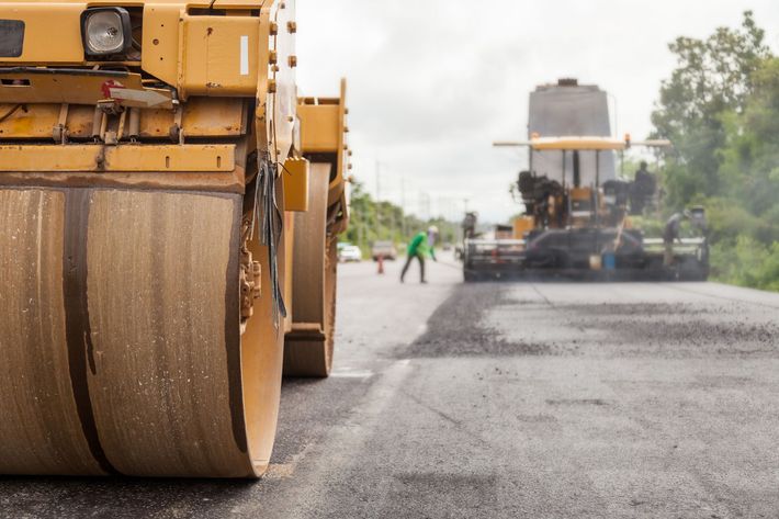 View of roller machinery in an asphalt job on a street.
