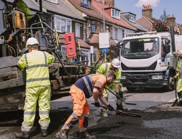 Group of asphalt contractors laying asphalt on a residential area.