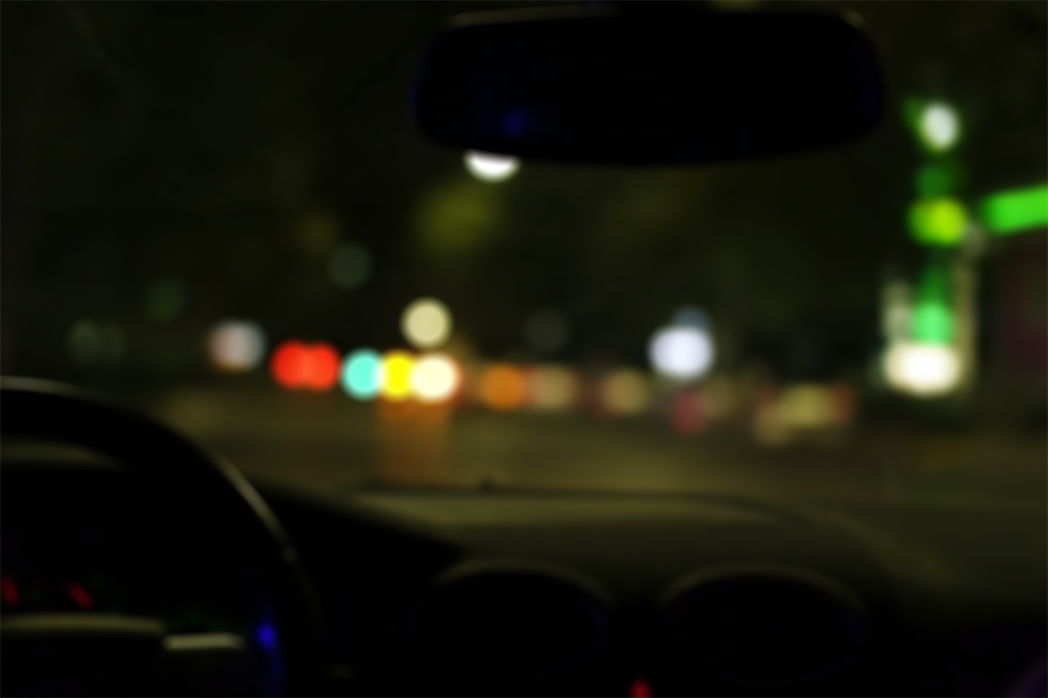 A blurry picture of a car driving down a street at night
