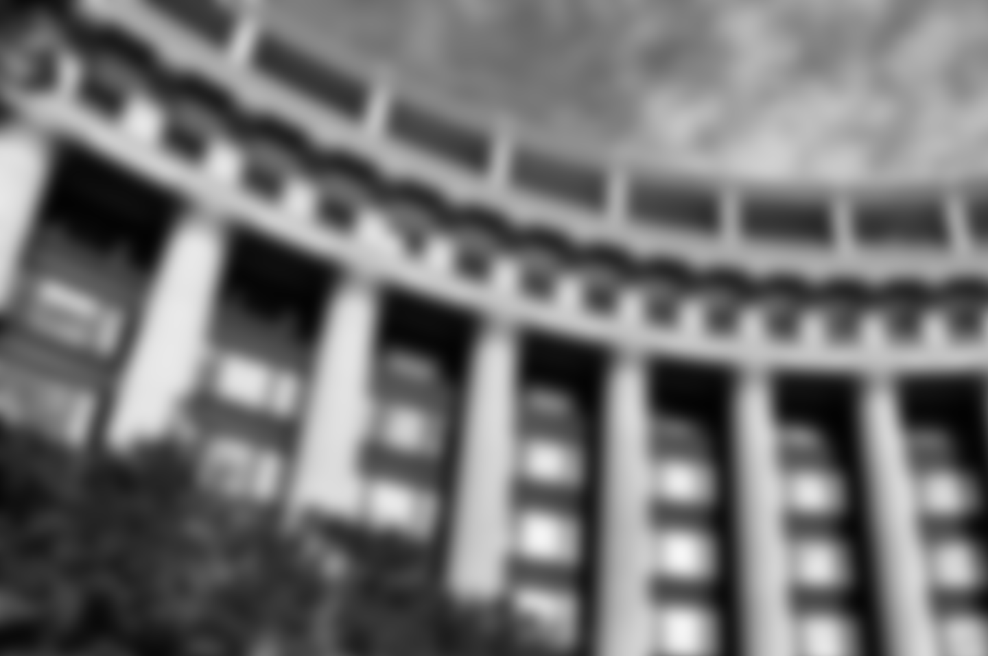 A black and white photo of a building with columns and arches.