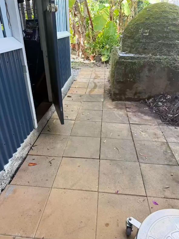 A Person is Using a High Pressure Washer to Clean a Brick Sidewalk — FNQ Cleaning Services in Mooroobool, QLD