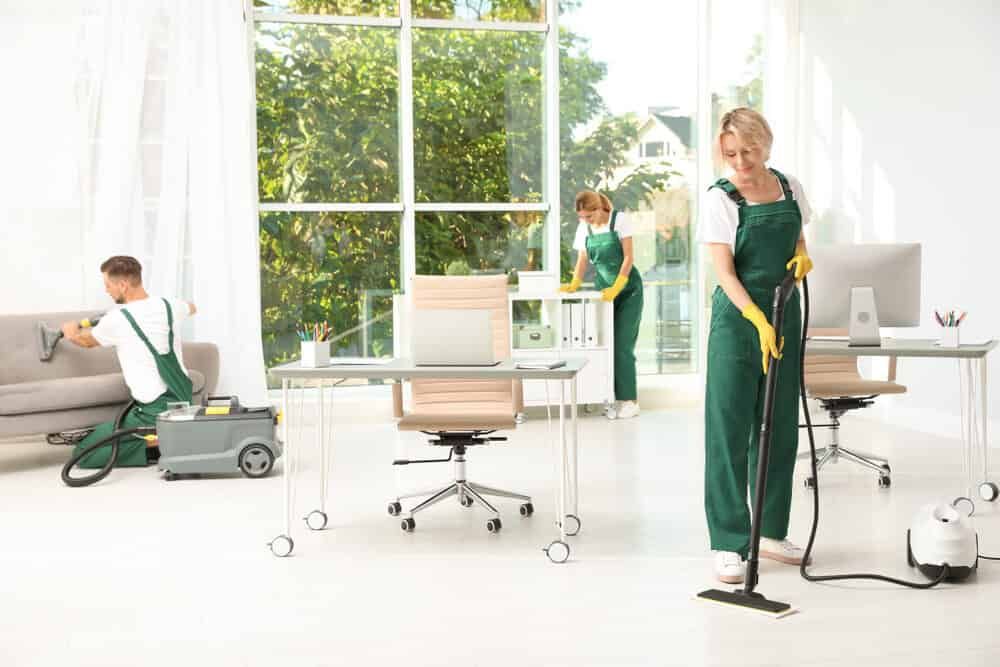 A Group Of Janitors Are Cleaning An Office — FNQ Cleaning Services in Mooroobool, QLD