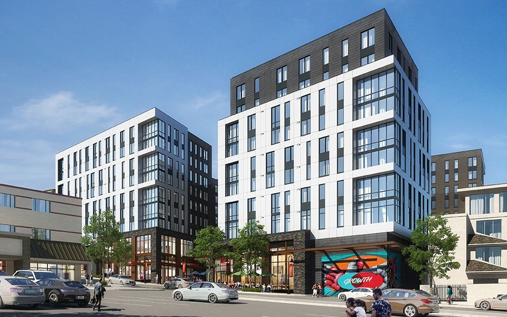 Modern mixed-use apartment buildings with large windows and street-level shops on a sunny city block