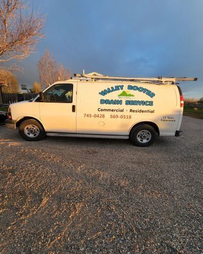 A white work van parked on a gravel lot under a sunset sky, with the text 