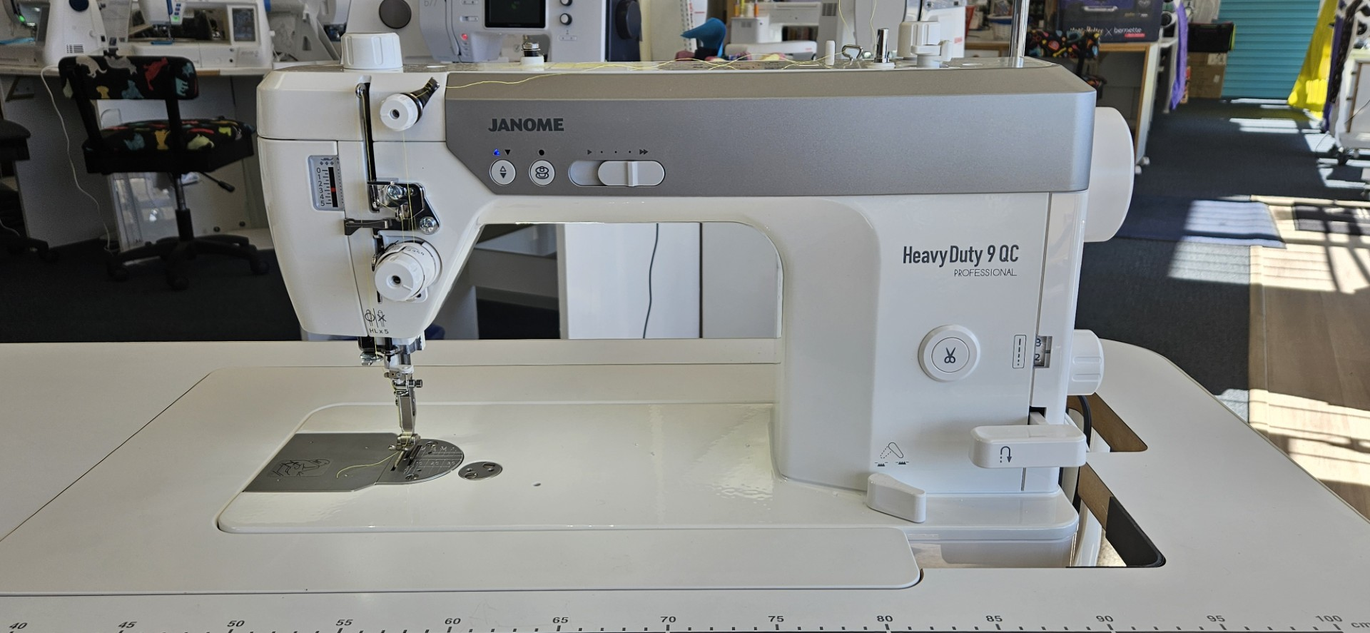 White portable sewing machine with purple controls and carrying handle on a white background