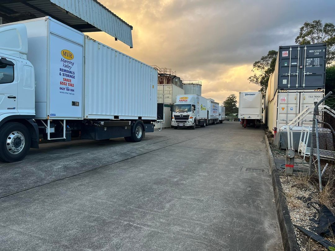A Row Of White Trucks Are Parked In A Parking Lot — Taree Containers in Taree, NSW