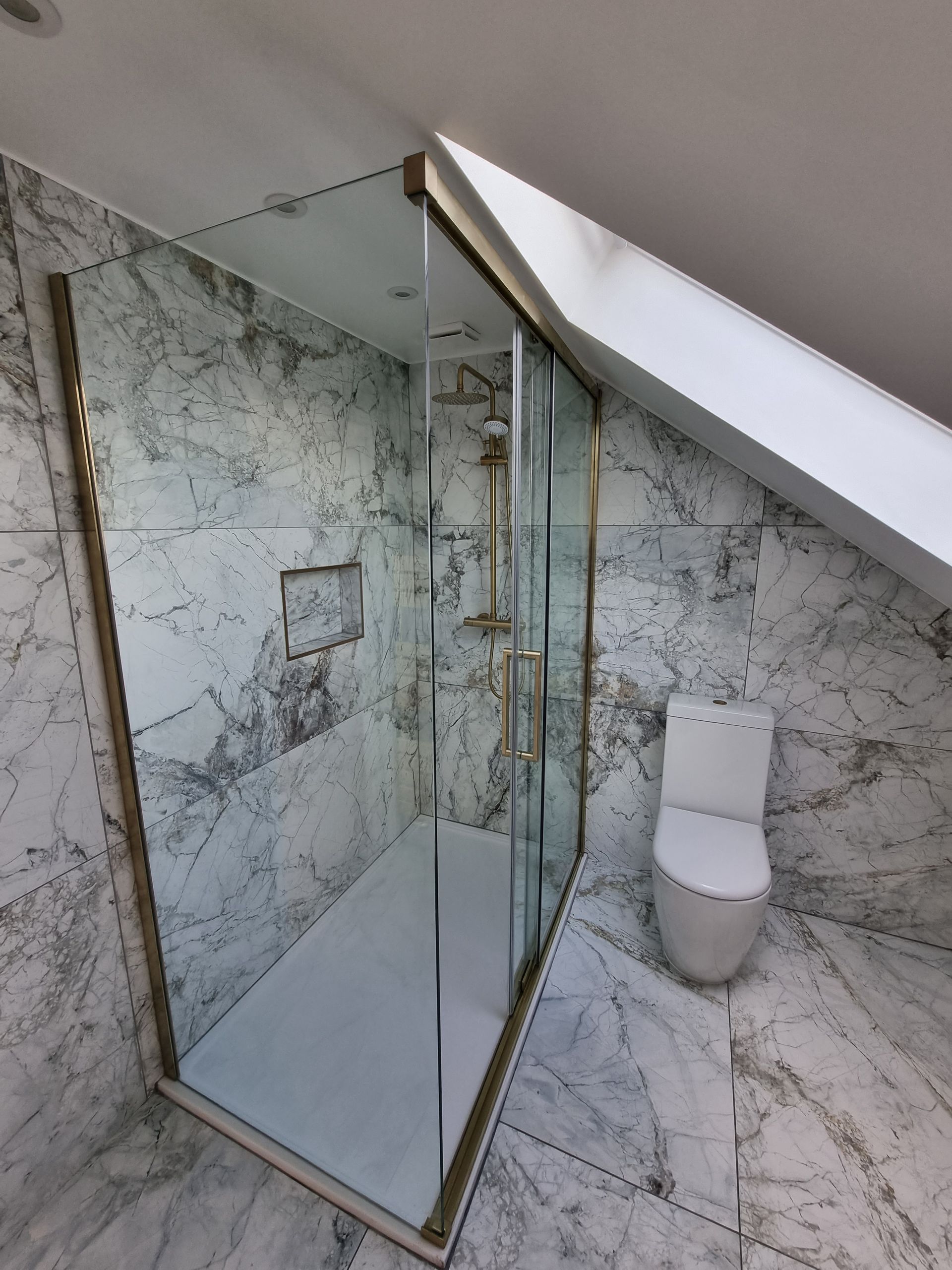 A bathroom with a toilet and a walk in shower