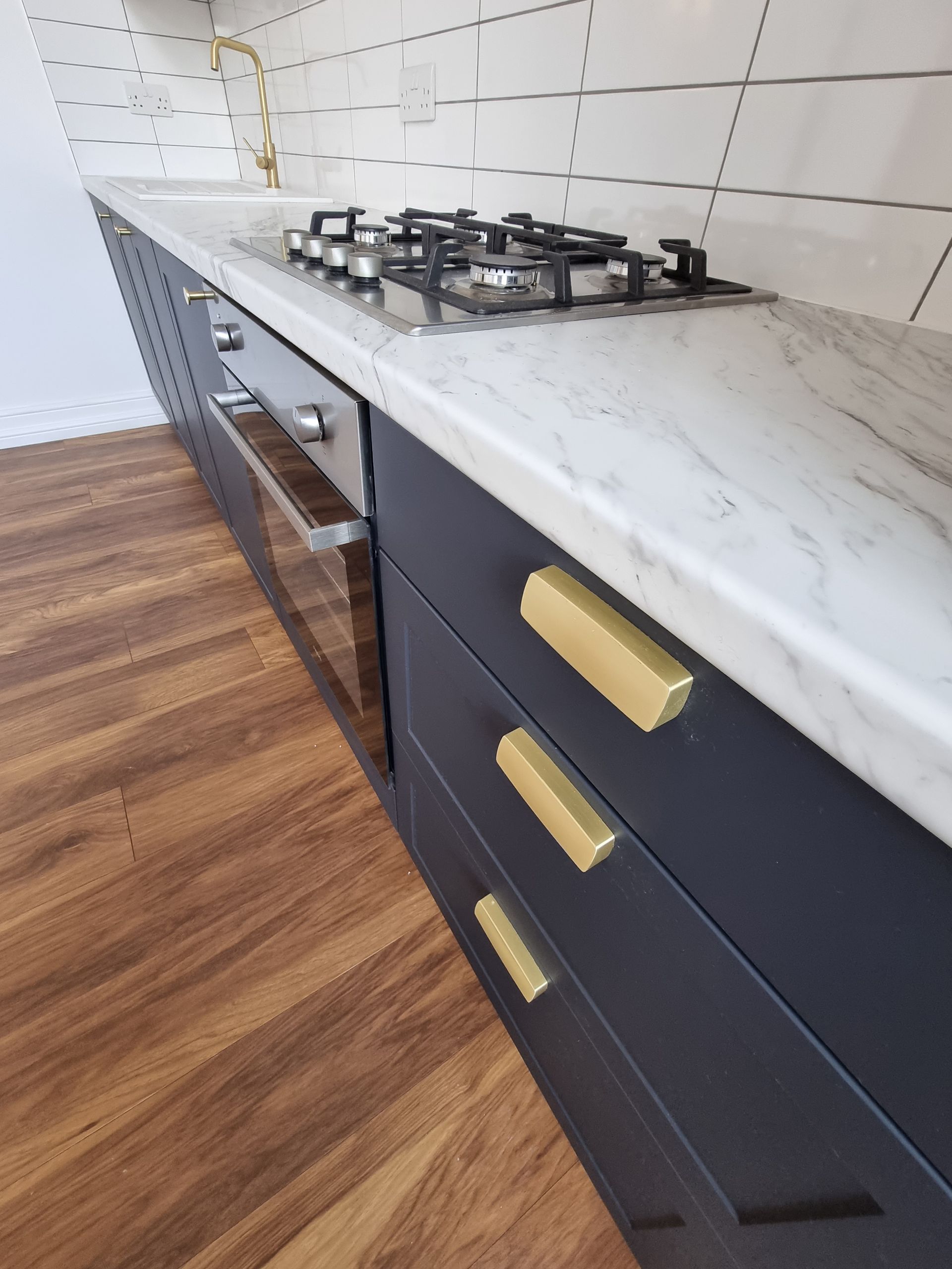 A kitchen with black cabinets and marble counter tops