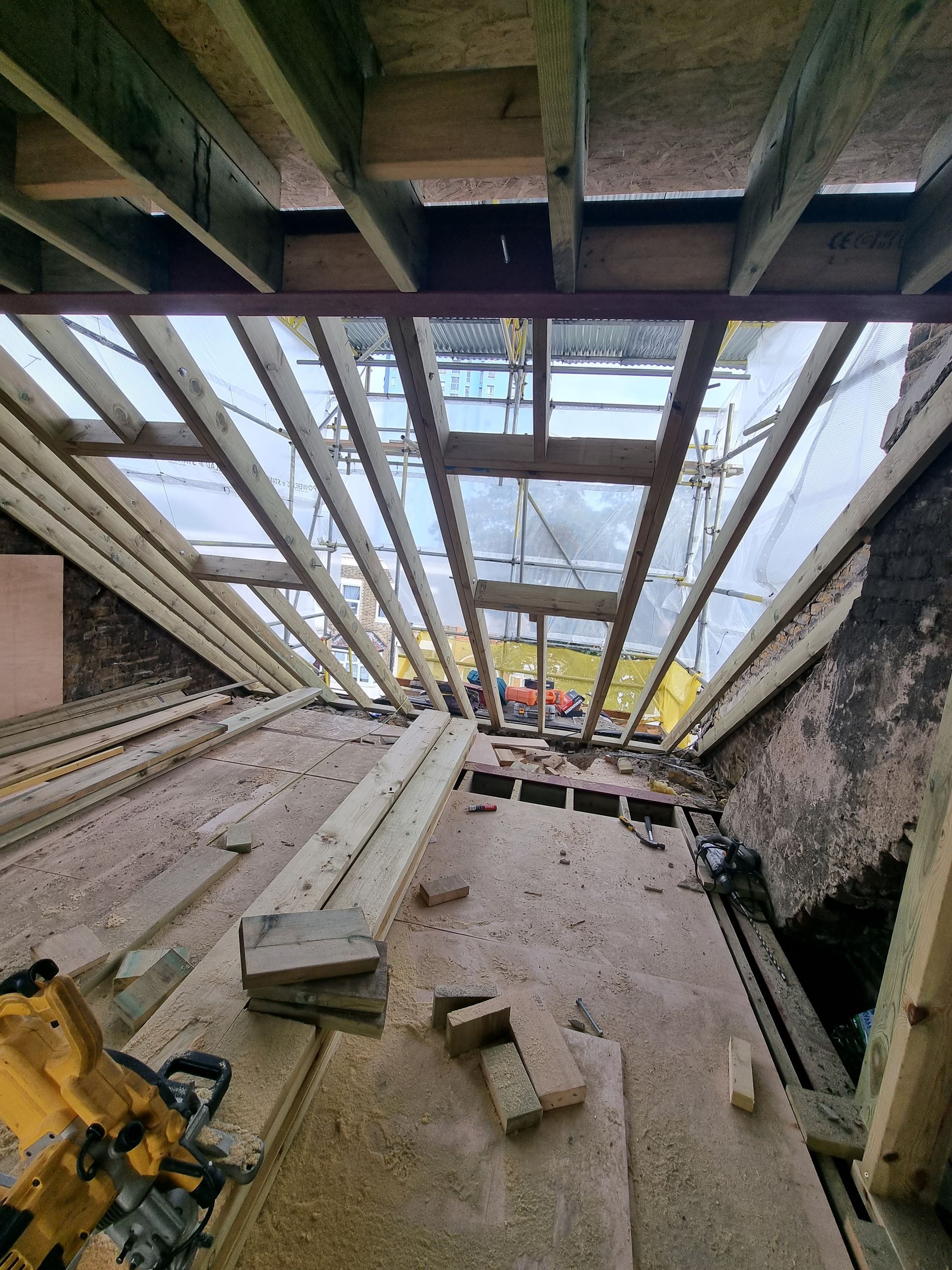 The ceiling of a building is being built with wooden beams.