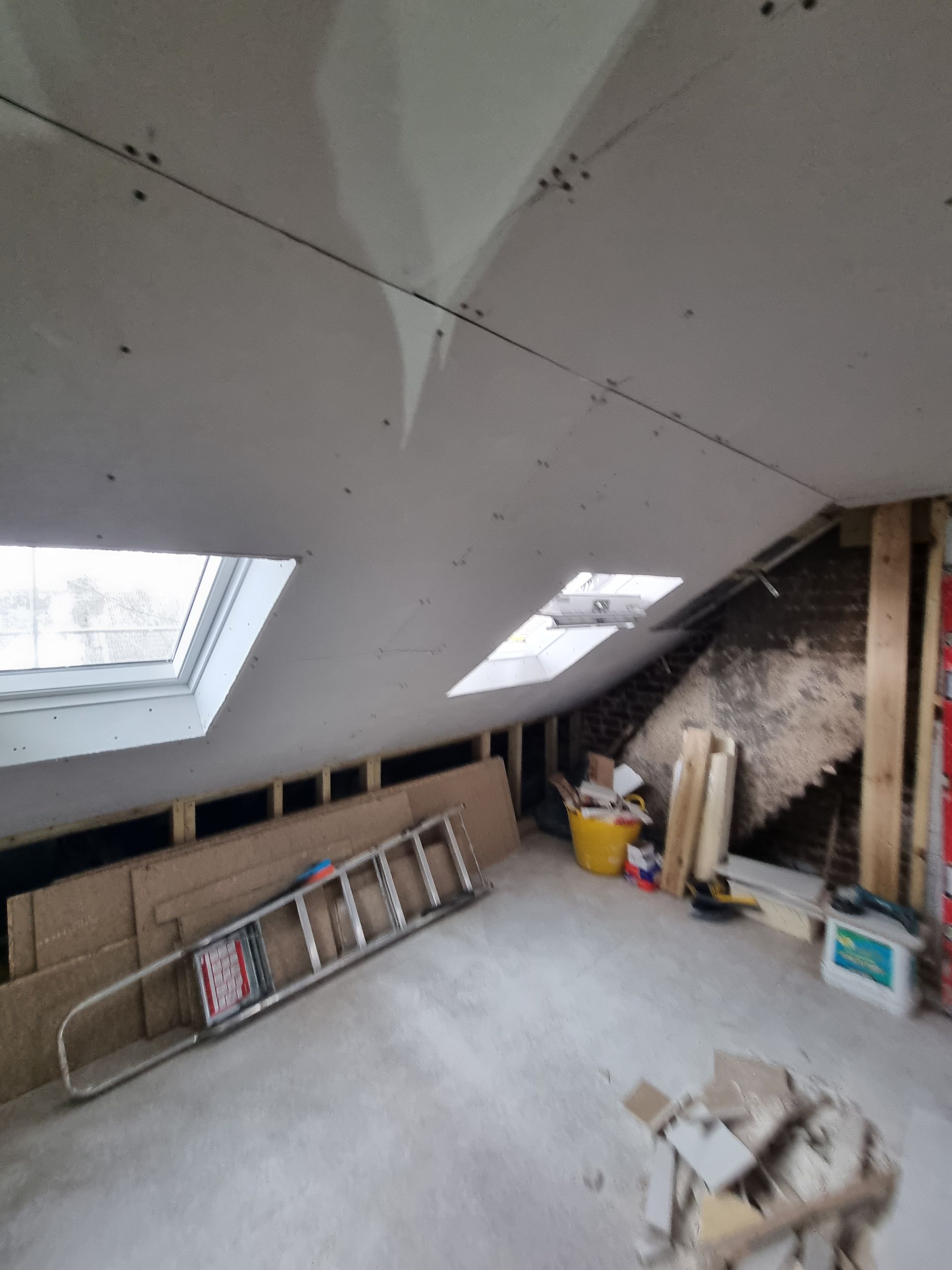 An attic with a ladder in the middle of it