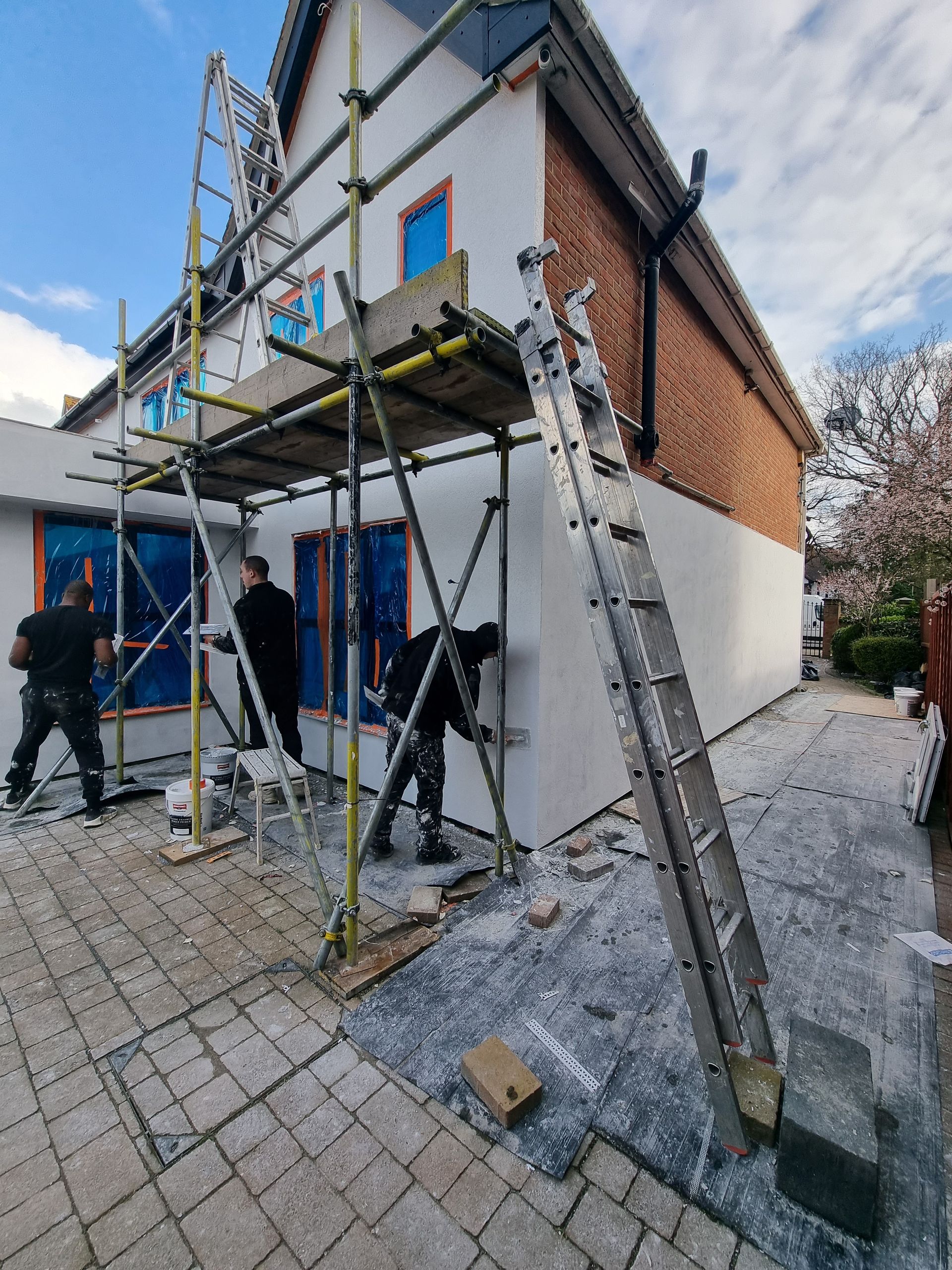 A house is being painted with scaffolding and a ladder.